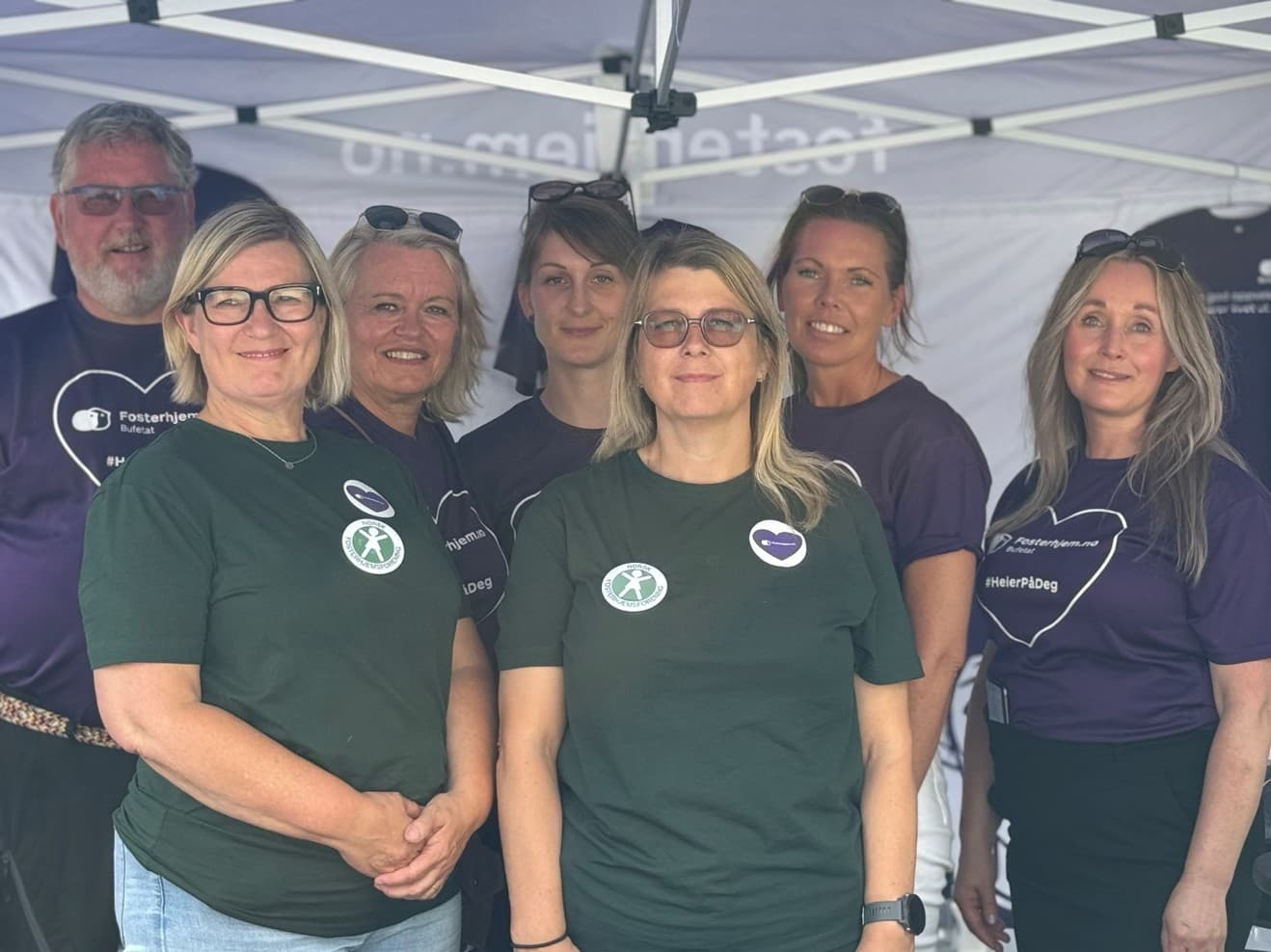 Fosterhjemstjenesten og styret i NFF står på stand i hhv. lilla og grønne t-skjorter