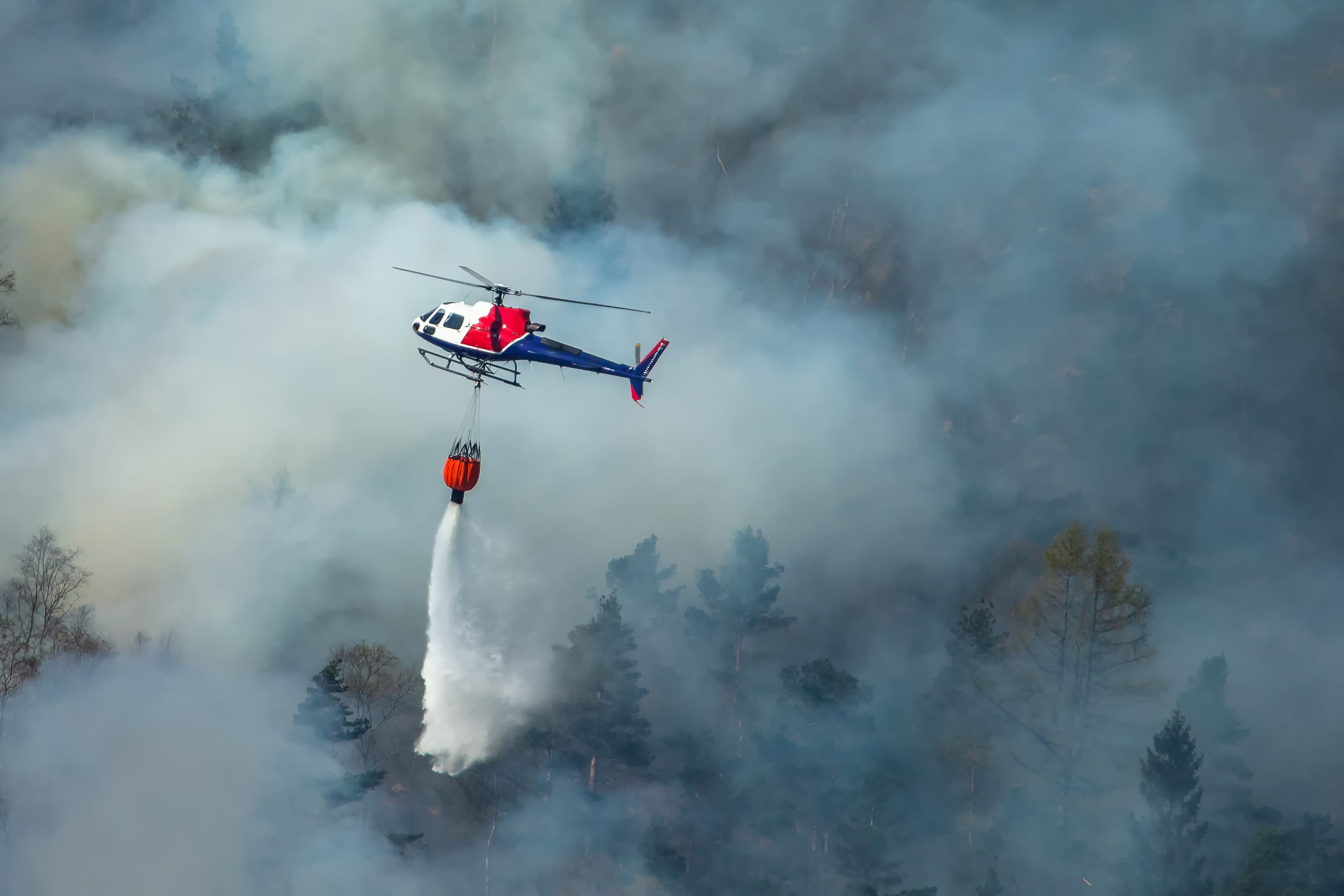 Brannhelikopter slipper vann over store røykmengder.