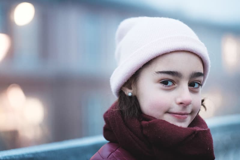 ung jente smiler smått og ser til siden