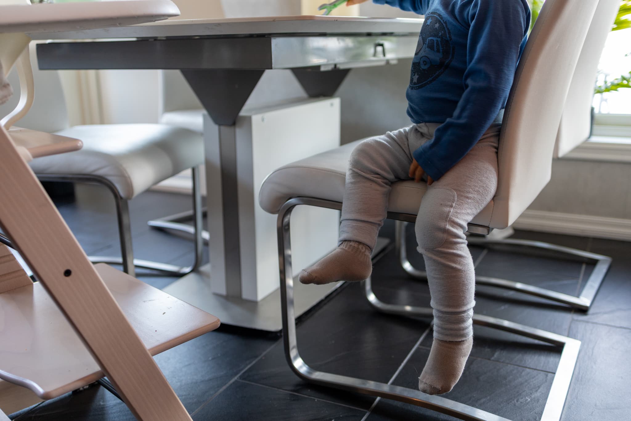 små føtter under et middagsbord