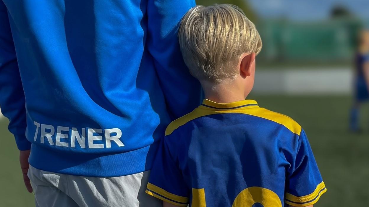 gutt i fotballdrakt med ryggen til