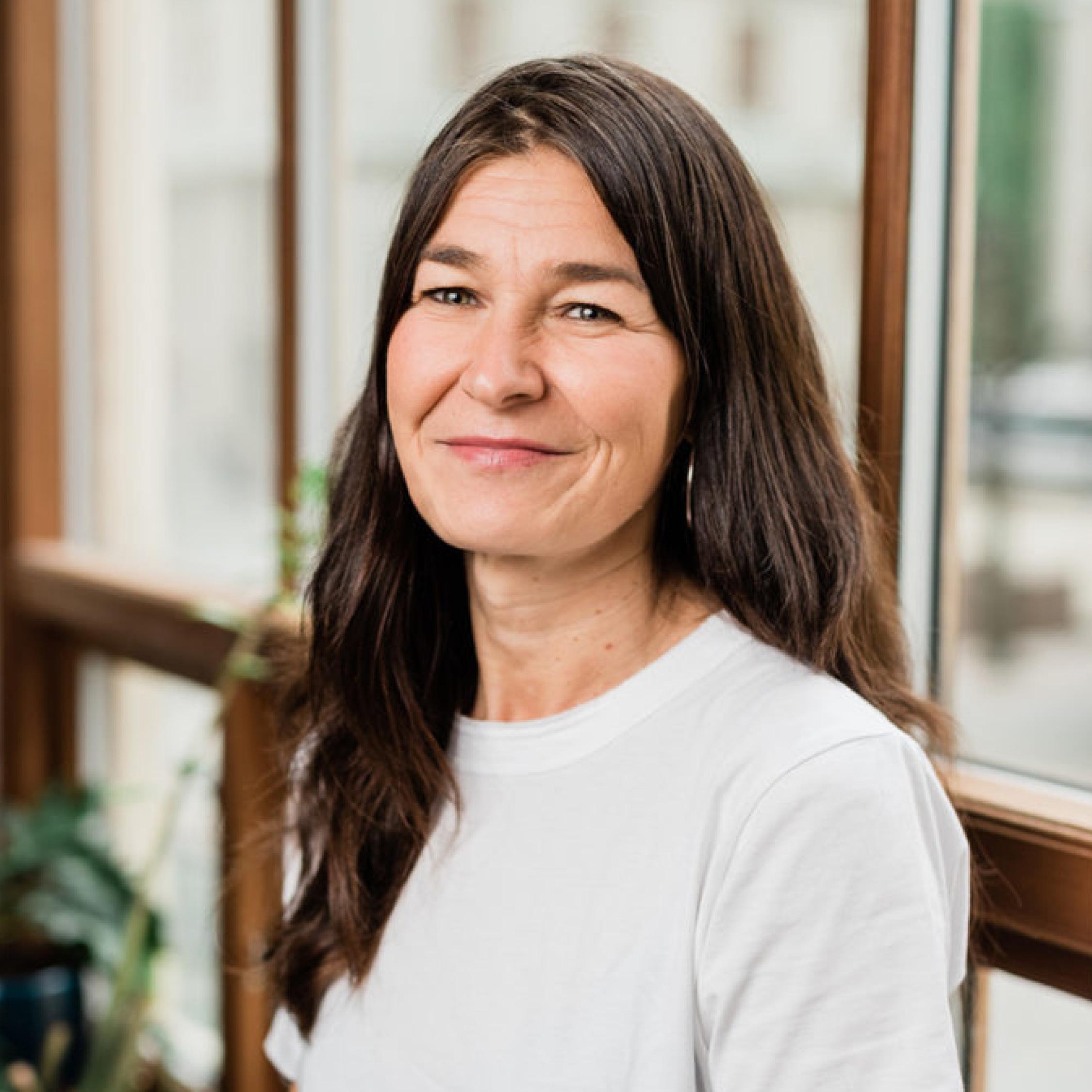 Portrett av Bente Austbø som ser inn i kameraet og smiler. 