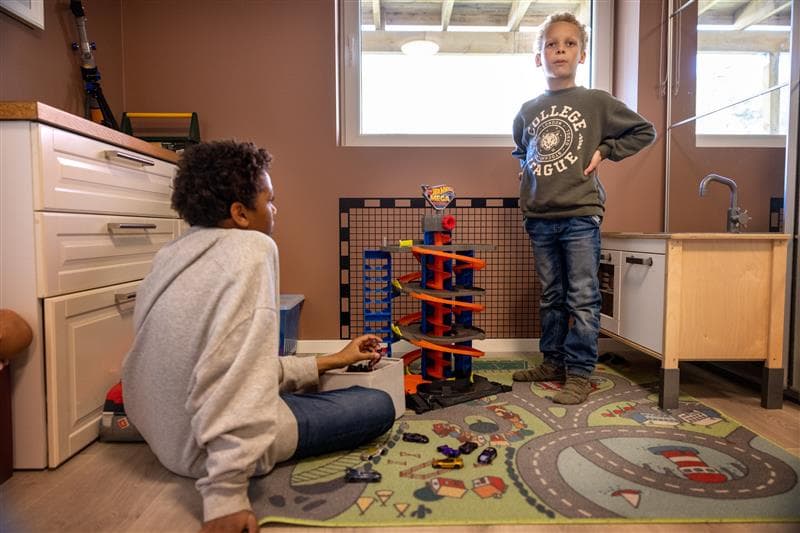 To barn leker med en bilbane på et barnerom