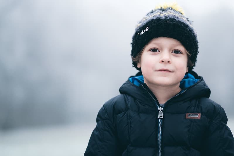 gutt med lue som smiler