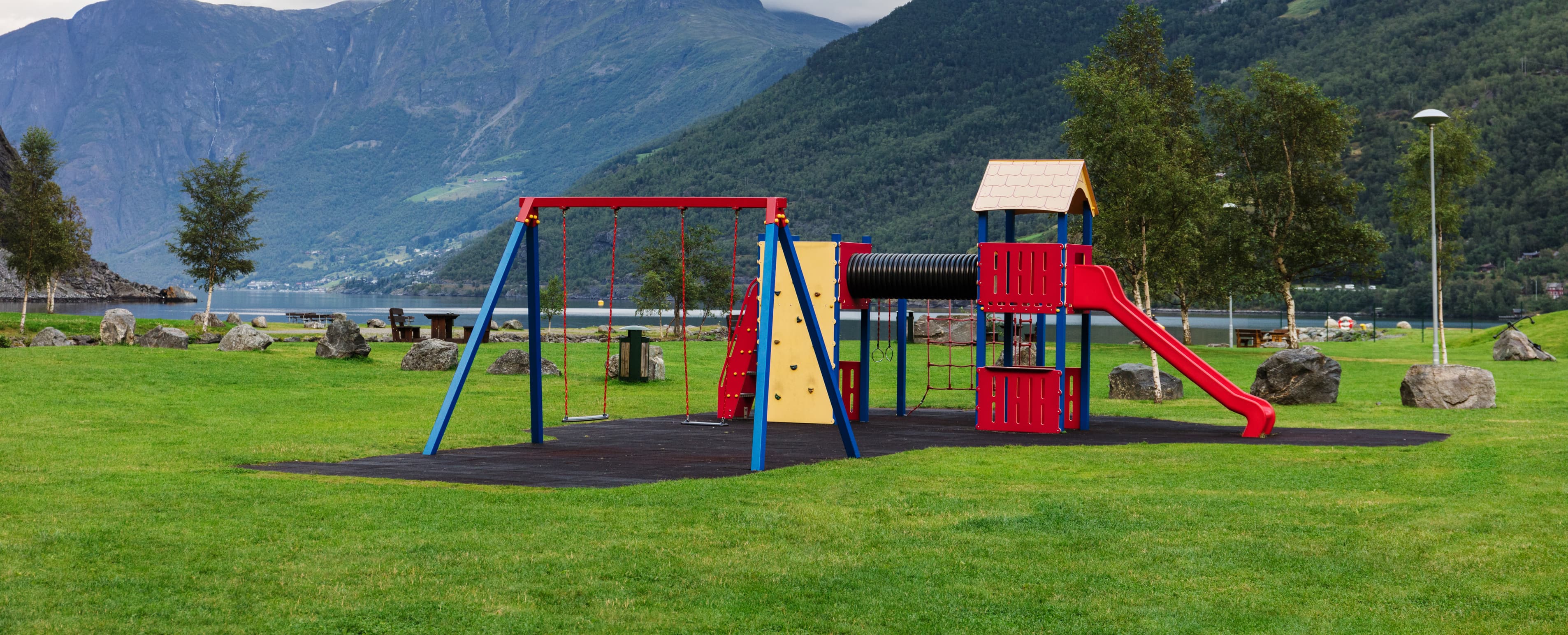 Klatrestativ som står på en gressplen, med svart underlag under selve stativet.