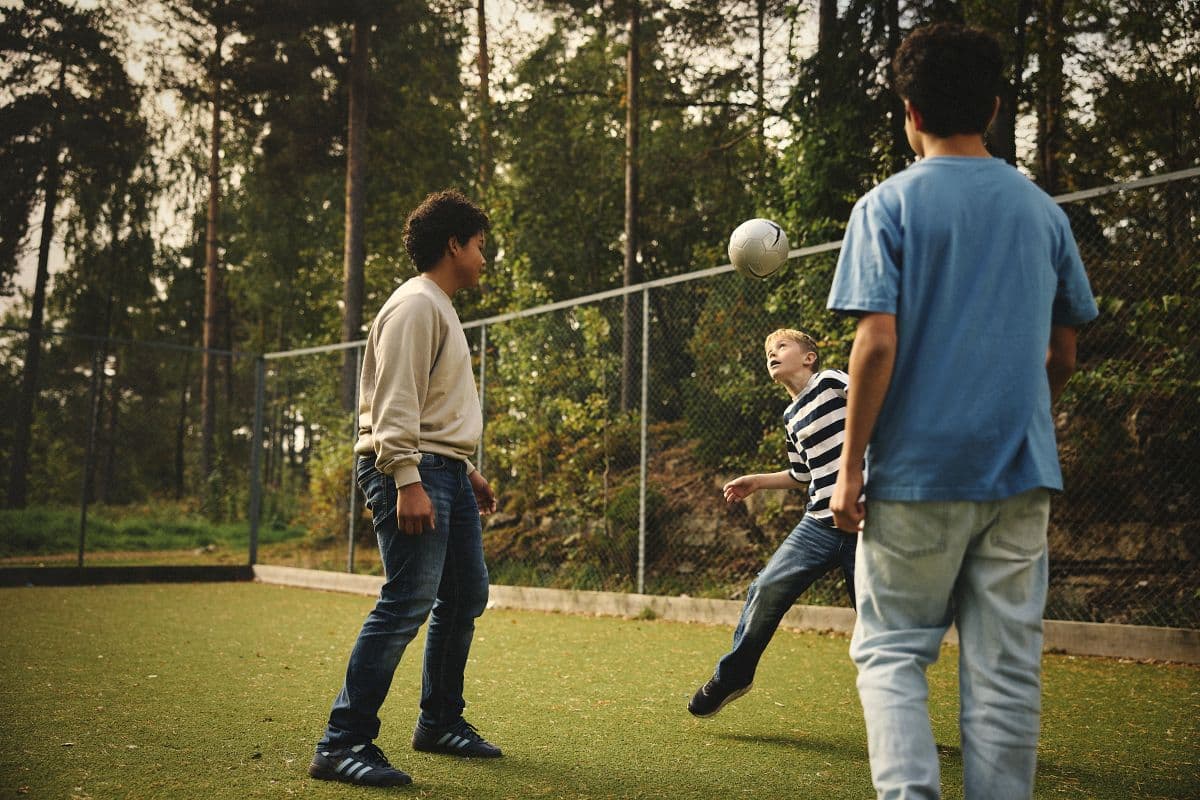 Tre gutter som spiller fotball