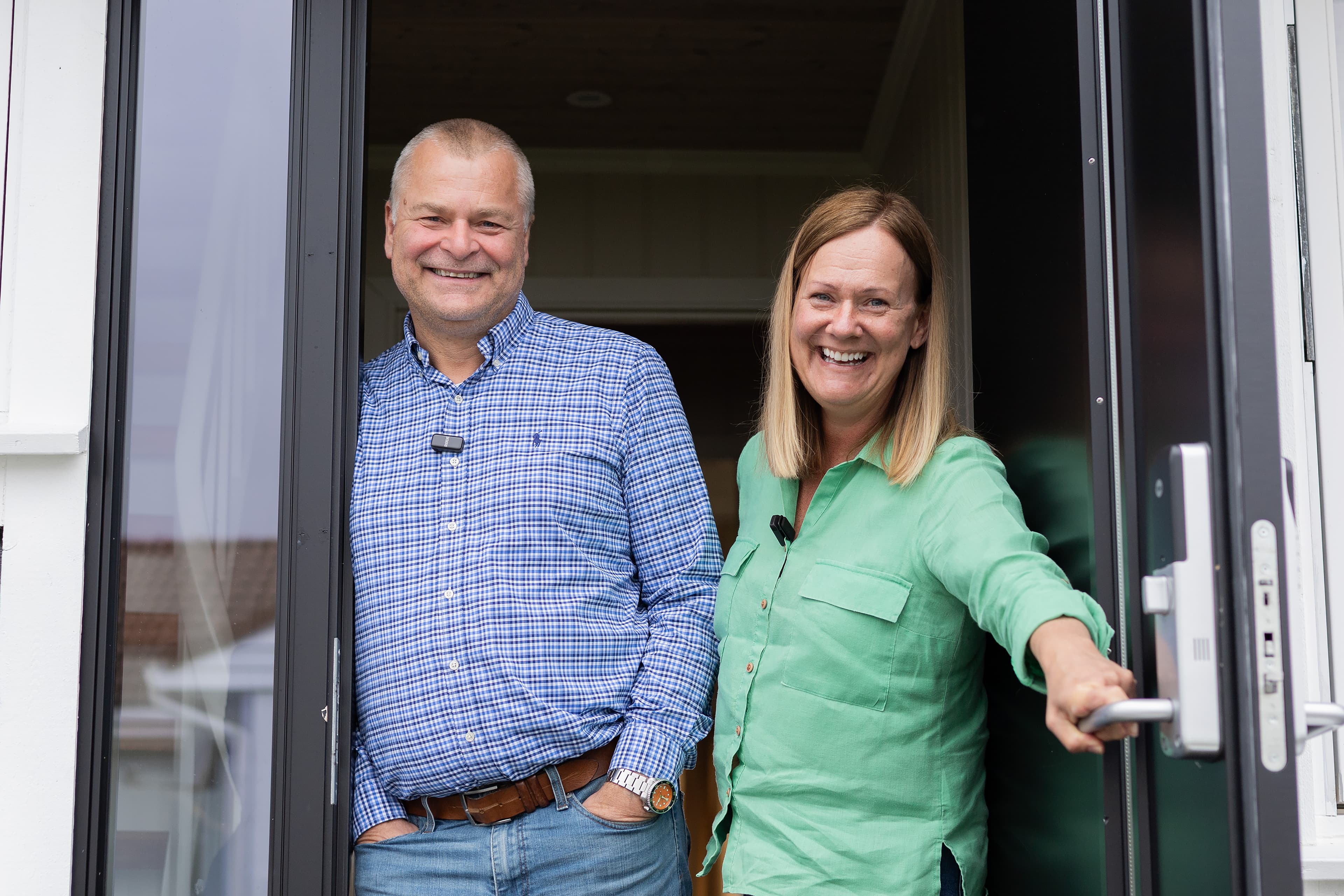 Mann og kvinne smiler i døråpning