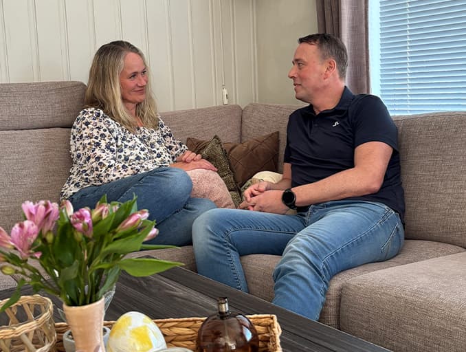 Kvinne og mann som sitter i en sofa