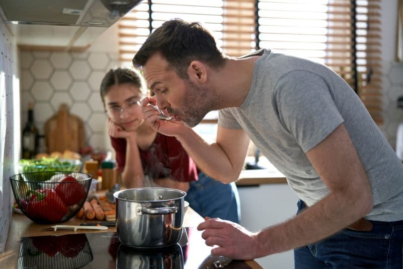 En voksen og en ungdom lager mat sammen. Foto.