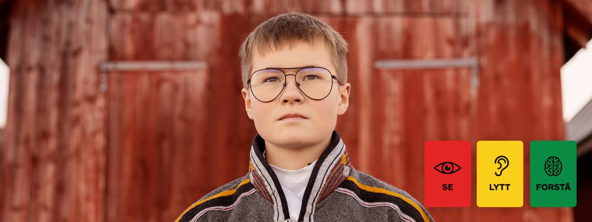 gutt står foran et naust.