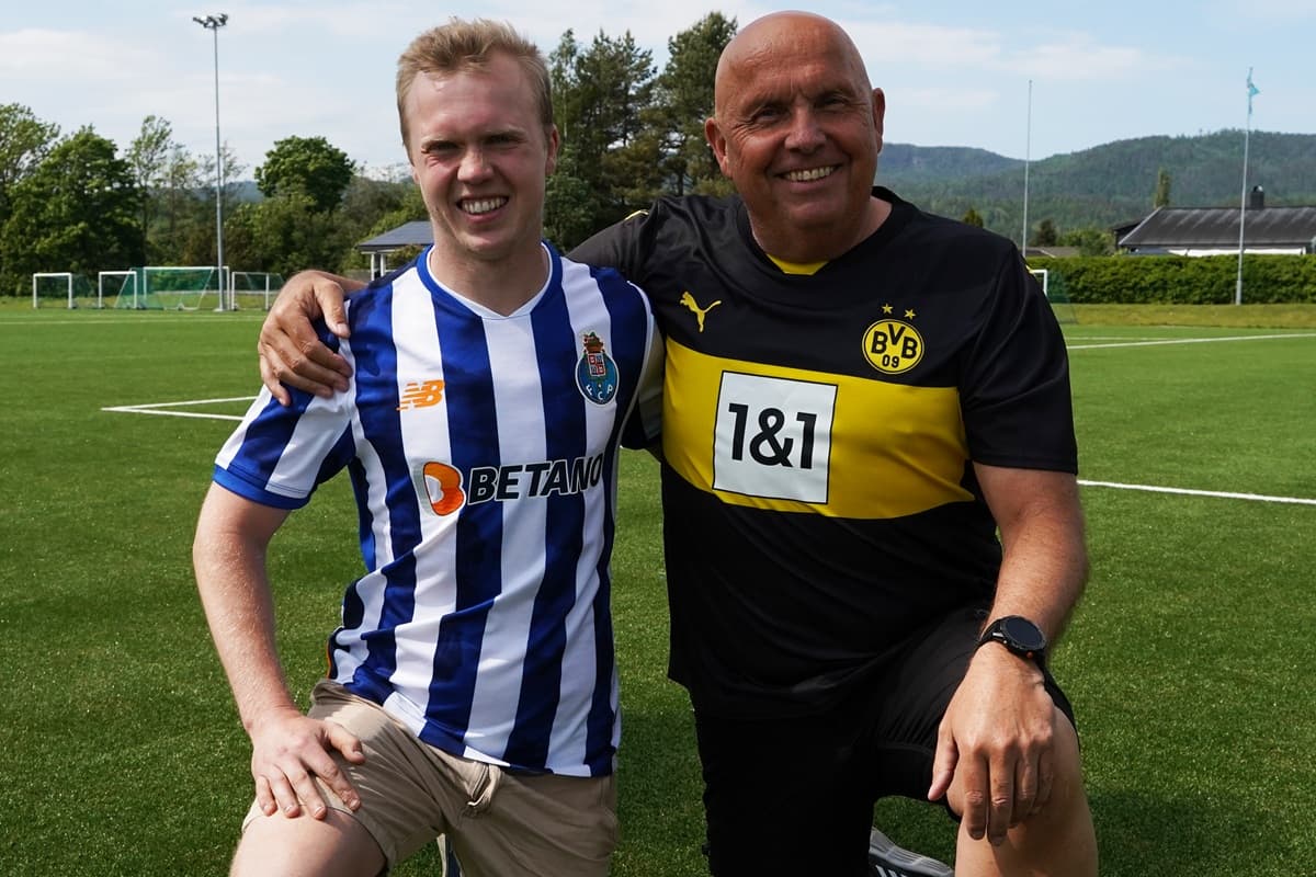 Dan Robin og Tor Martin står oppstilt smilende på en fotballbane, med fotballtrøyer på