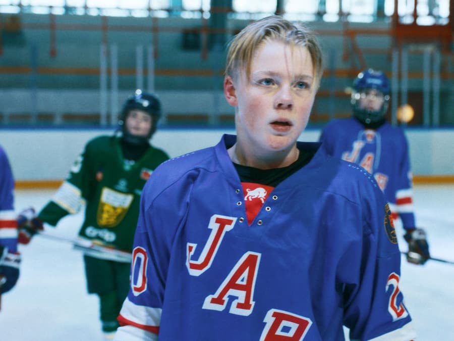 Ung hockeyspiller i lagdrakt ute på isen