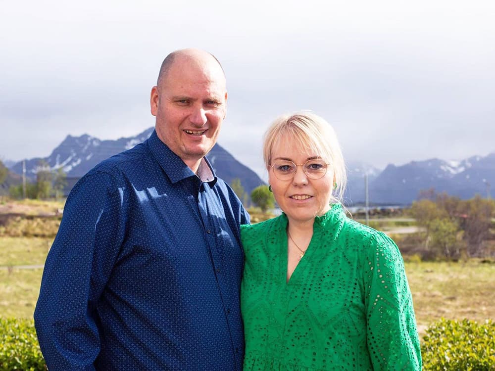 En mann og en kvinne utendørs, foran et fjellanskap i det fjerne