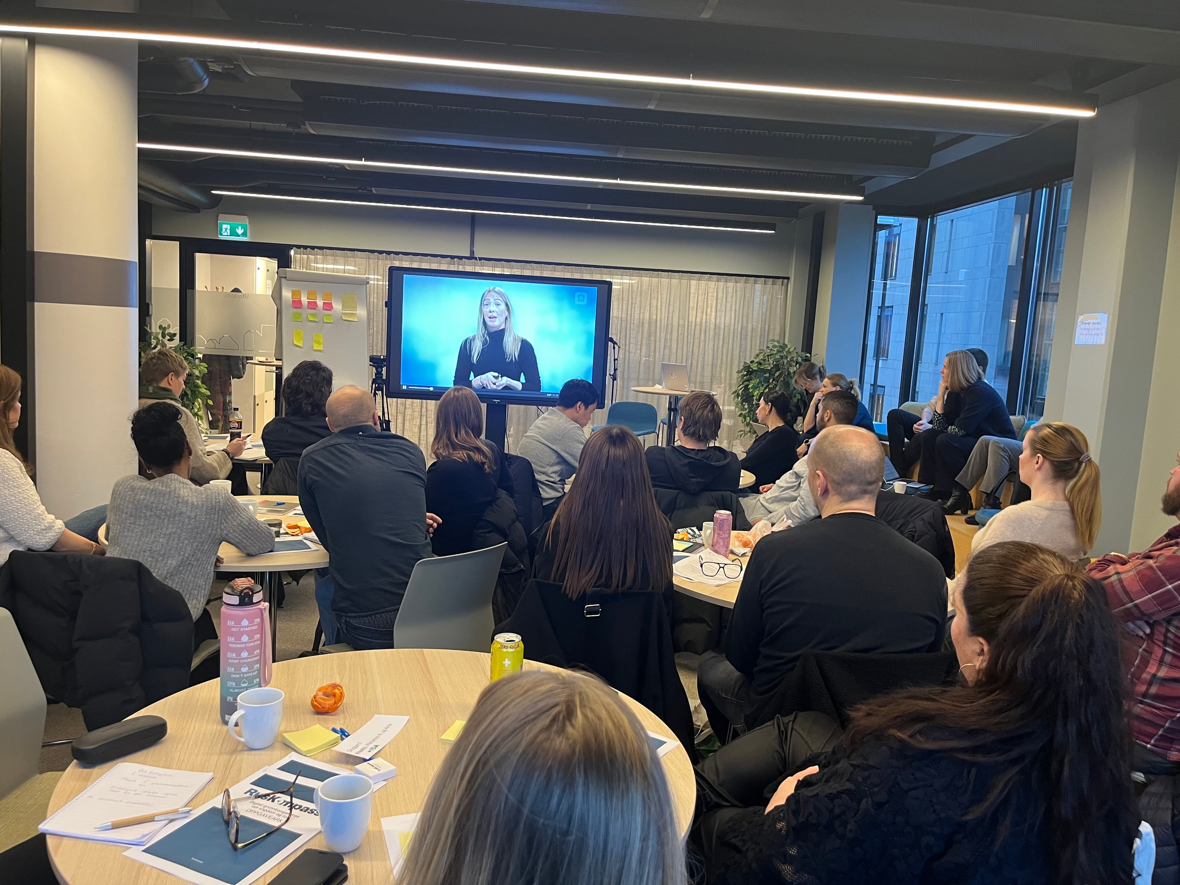 En forsamling som ser på storskjerm.