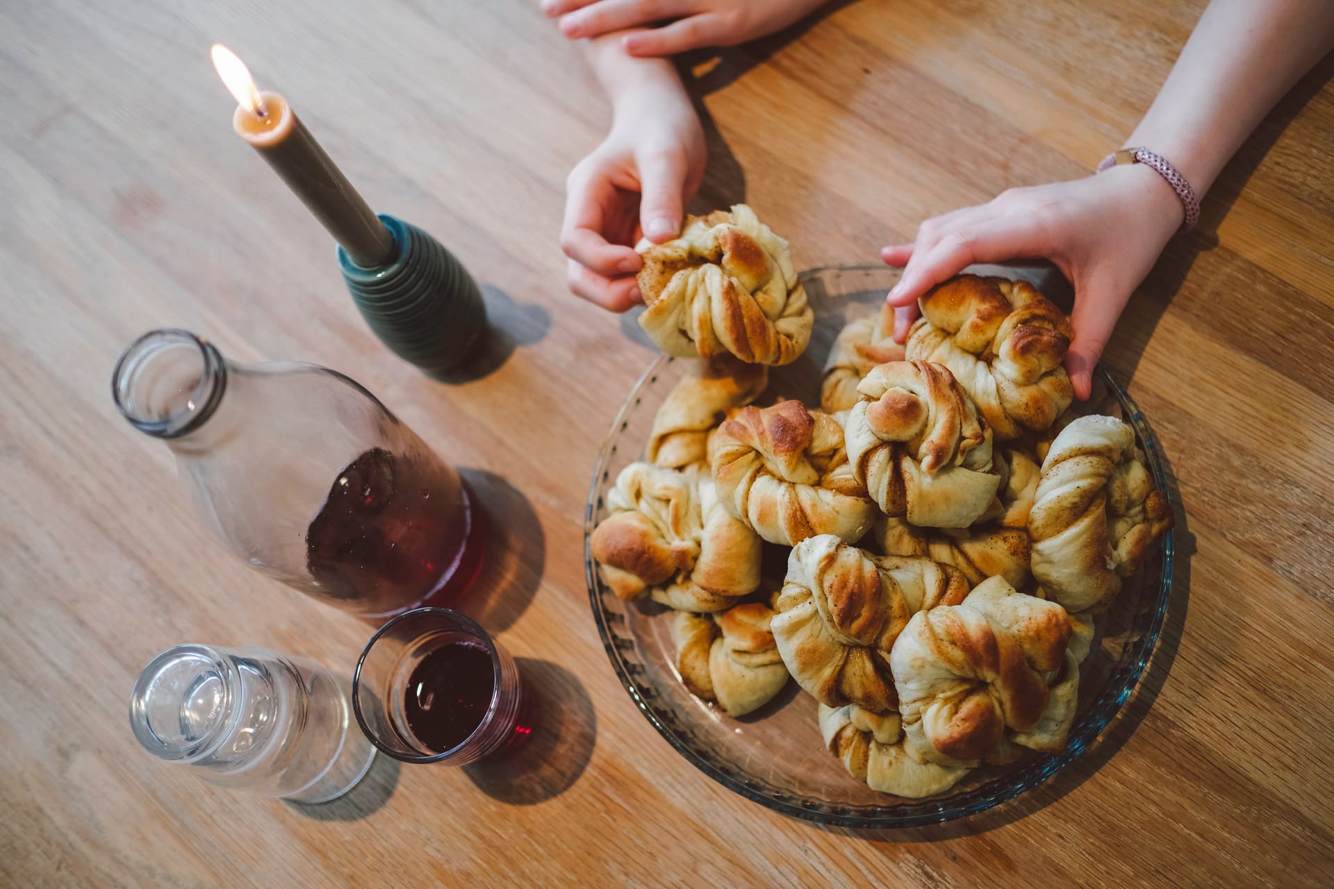 To hender som rekker etter boller på et fat