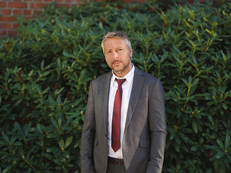 Divisjonsdirektør i Bufdir Kjetil Andreas Ostling står i dress og slips foran en grønn bakgrunn