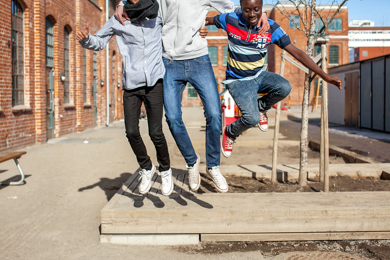 Tre ungdommer som hopper