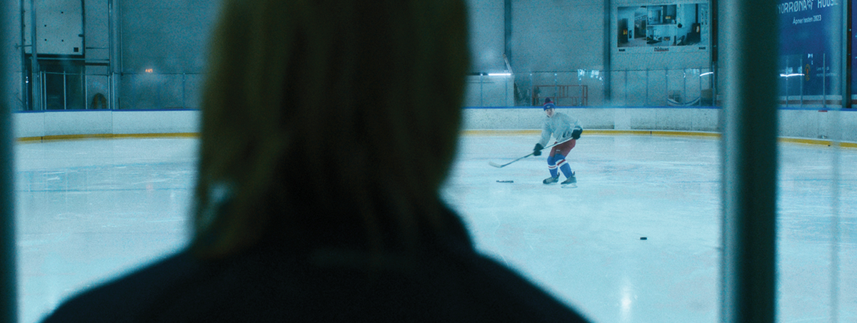 Ung gutt spiller hockey alene mens treneren ser på